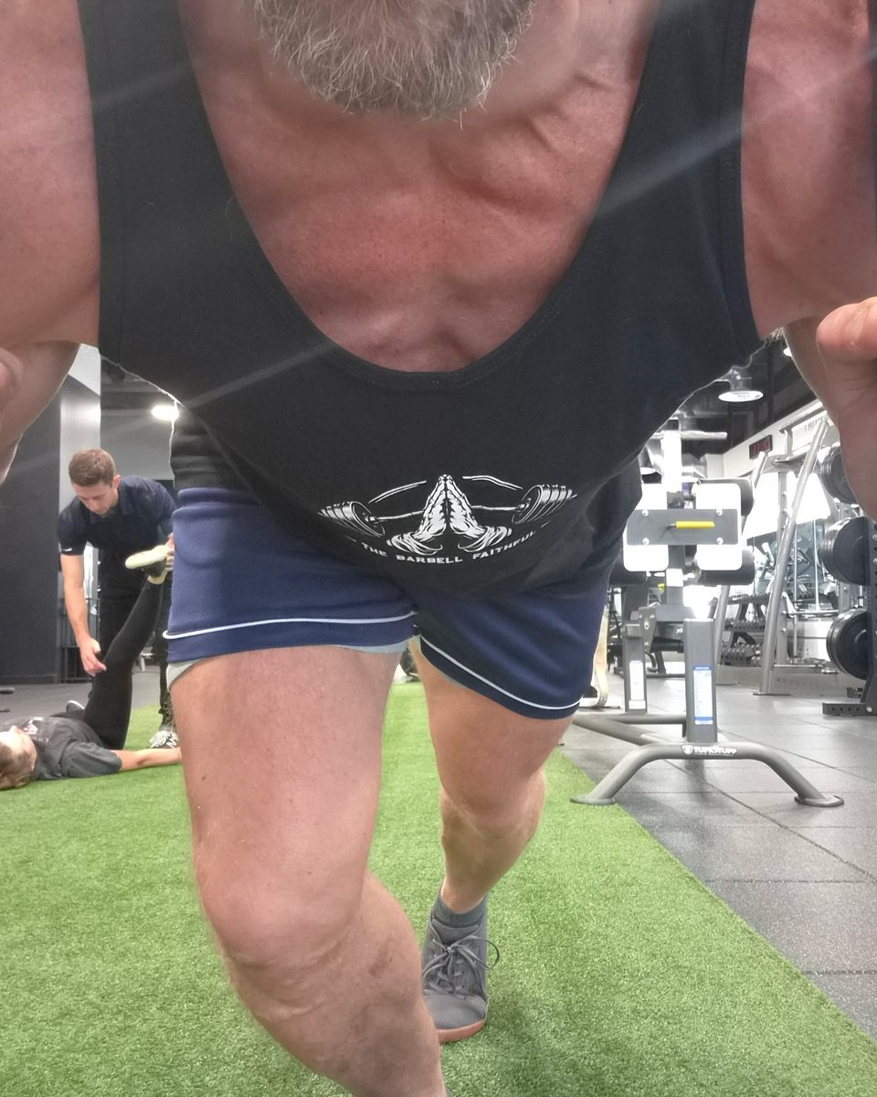 Pushing the sled in the black Barbell Faithful tank