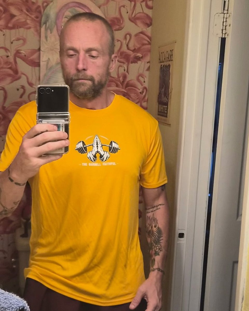 Wearing the gold Barbell Faithful performance tee